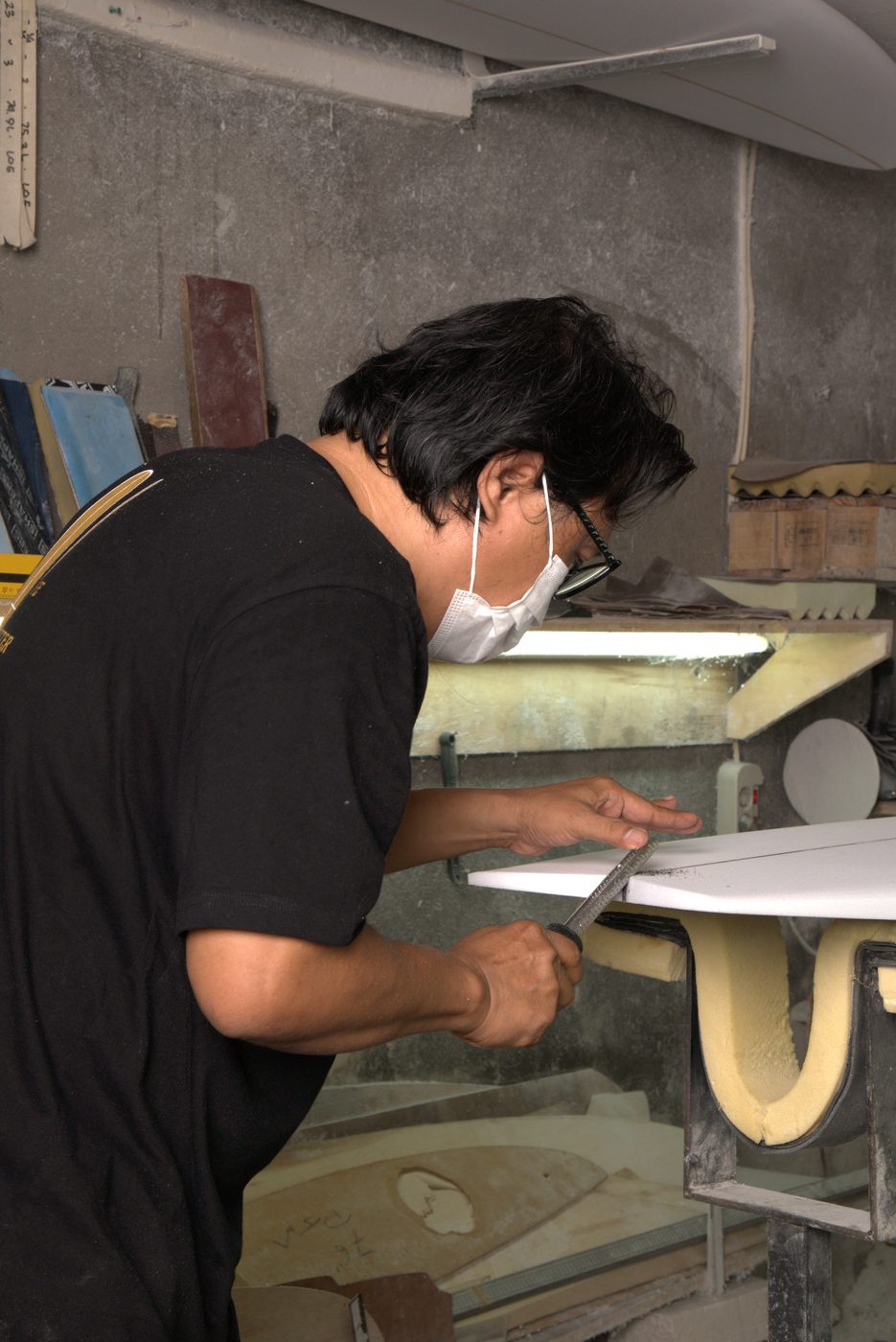 Budi shaping the rail of a board